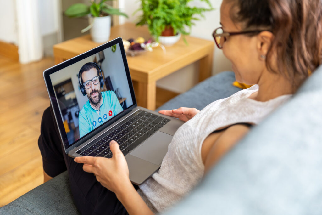 Woman at home on a video call with man - happy couple talking at