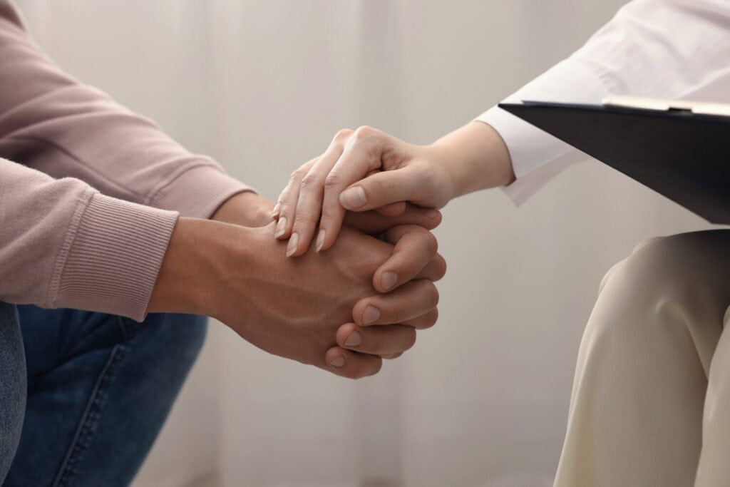Professional psychologist supporting patient during therapy in office, closeup